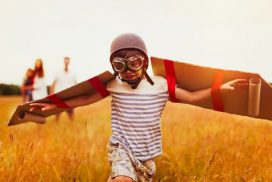 Un niño con alas de cartón y disfraz de aviador, jugando a volar, a su manera, está consiguiendo su sueño