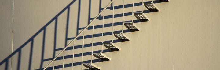 Los peldaños de una escalera pegada a la pared proyectan sombras que proyectan una fantasía dirigida a ver otra escalera. 