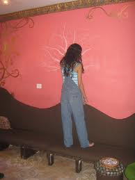 Una niña dibuja en una pared, el trabajo con la imaginación activa y niño interior despierta nuestra creatividad