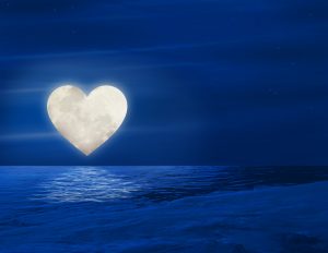 Sobre un cielo nocturno, la luna diseñada como un corazón, mitos del amor romántico.