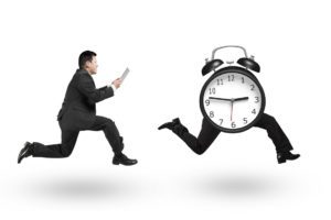 Un hombre corre detrás de un reloj como si se le escapara el tiempo. Superar el tabaquismo requiere tiempo y dedicación. 