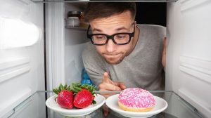 Un hombre en la nevera va a elegir entre un plato calórico y otro saludable, es posible adelgazar sin dieta estricta