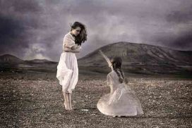 Fotografía de una mujer y una niña, vestidas igual, mirándose. La terapia del niño interior nos conecta con nuestra infancia