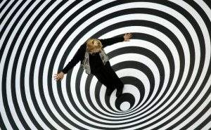 Una mujer se ve atrapada en una espiral que parece succionarla hacia abajo, como un patrón de conducta repetitivo circular.