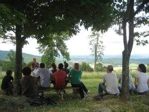 Personas diversas escuchando una charla en el campo. La programación neurolingüística se adapta a cualquier persona. 