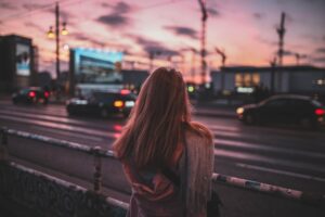Una dona observa apessegada una grisa ciutat, sentir els sentiments sense evadir-nos de la realitat amb l'alcohol