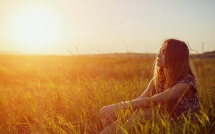 Una mujer acaricia unas espigas en el campo, la fenomenología en psicoterapia nos permite percibir con atención