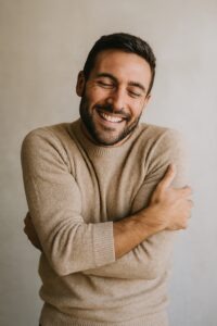 Un hombre abrazándose a sí mismo, cultivando el amor propio. 