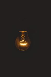 Una bombilla emite un destello de luz, metáfora del grounding para aclarar la mente. 