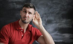 Un hombre en gesto de escucha, atender las necesidades y sentimientos de las personas. 