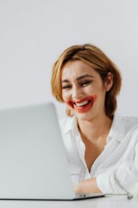 Mujer sonriente en el trabajo con los labios mal pintados. 