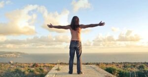 Un hombre con los brazos abiertos, el grounding psicológico favorece la apertura a la vida. 