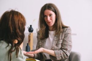 Dos mujeres conversan en un entorno terapéutico.