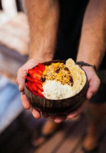 Unas manos ofrecen un bol con comida. 