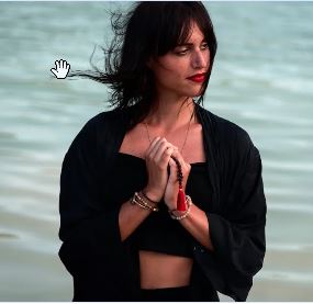 Mujer en el mar en actitud meditativa cultivando la conciencia presente, aquí y ahora.  