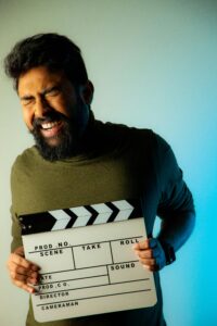 Un hombre sostiene una claqueta de cine con guion de vida de perdedor. 