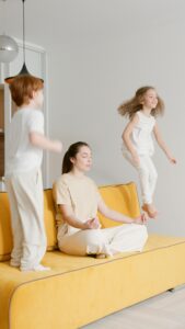 Dos niños saltan mientras la madre practica mindfulness
