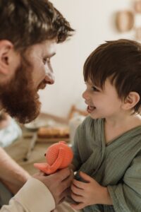 Un hombre habla amorosamente con su hijo, como la técnica del diálogo del adulto con el niño interior que forma parte de las afirmaciones positivas poderosas y realistas. 